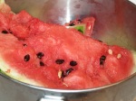 Photo of ripe red watermelon in steel bowl.